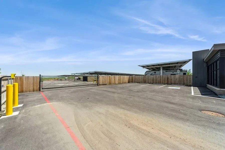 Parking spaces in front of the security office and entry gate for a RV parking lot. A RV can be just beyond the fence.