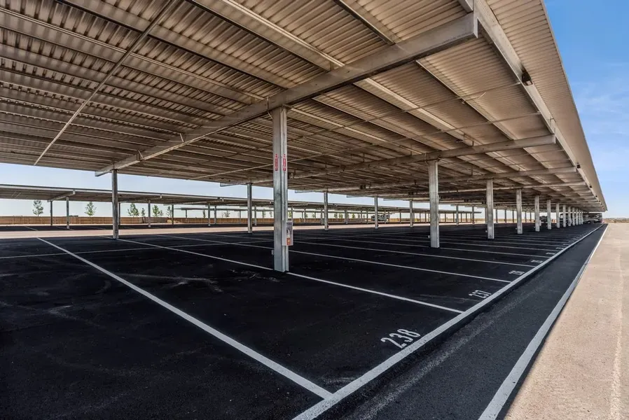 Empty lot of covered parking space with a few RVs parked in the distance.