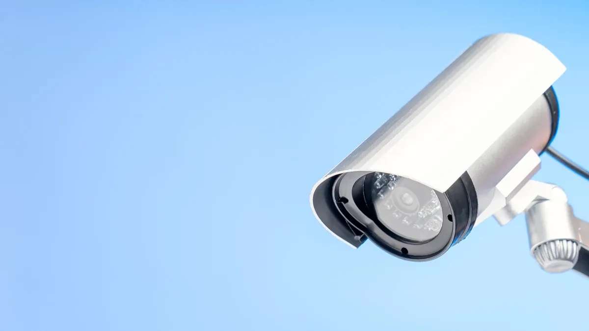 A security camera pointing down on a blue background.