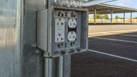 Power outlet with cover at parking space.