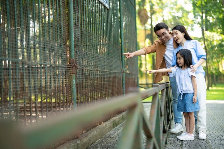 A family spending time together at a zoo. 