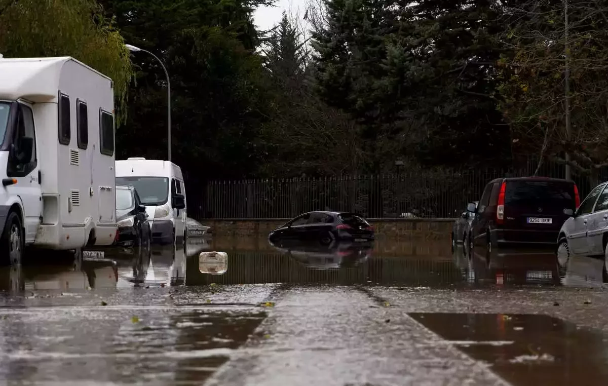 RVs and cars on a street with flooding roads.