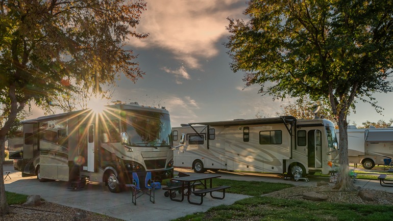 2 RV's parked at a campground at dusk