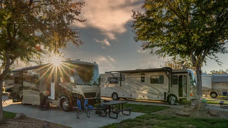 2 RV's parked at a campground at dusk