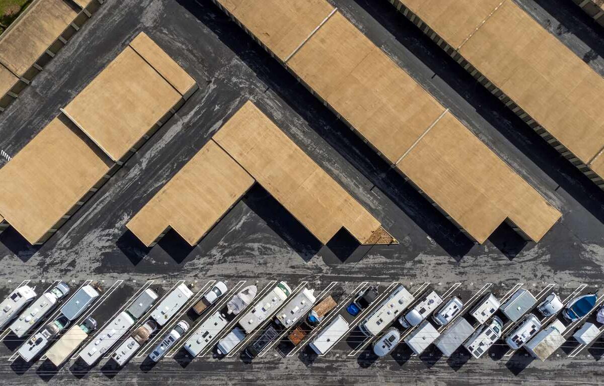 Covered and uncovered RV storage spaces with multiple recreational vehicles parked in organized rows.