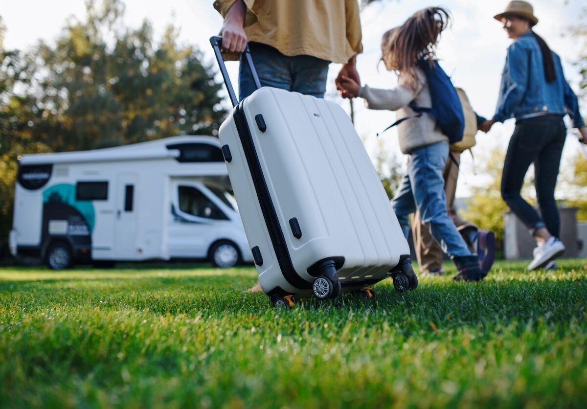 A young family with luggage preparing for an RV road trip.