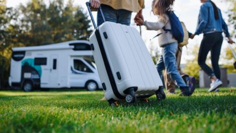 A young family with luggage preparing for an RV road trip.